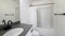 Pano Bathroom interior with black fixtures and one piece shower tub with white shower curtain