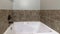 Pano Bathroom interior with drop in tub with brown tile surround