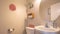 Pano Bathroom interior with toliet adjacent to stand alone sink and round mirror