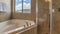 Pano Built in bathtub and shower stall inside bathroom with tiled floor and wall