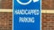 Pano Close up of Handicapped Parking sign against blurred red brick wall of church
