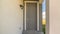 Pano Close up of home entrance with gray front door and lantern on the concrete wall