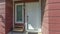 Pano Close up of townhouse facade with a bench by the white front door and window