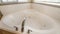 Pano Corner bathtub with widespread faucet against the two windows