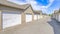 Pano Exterior of houses on a sunny day with white garage doors along paved road