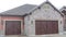 Pano Facade of garage of home with combination of stone and red wood exterior wall