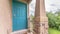 Pano frame Blue green door of a home with doormat railing and stone pillar at the entrance