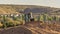 Pano frame Bulldozer on a mound of soil at a construction site against mountain and sky