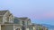 Pano frame Exterior of homes with gable and valley roofs against mountain and sky at sunset