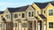 Pano frame Exterior view of townhomes with gable roof stairs and square columns at entrance