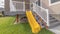 Pano frame Home exterior with stairs climbing plane and yellow slide that leads to porch