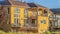 Pano frame Road amidst grassy land in front of beautiful homes against blue sky with clouds