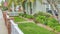 Pano Front yard of home with green lawn pathway wooden fence and red brick posts
