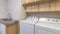 Pano Functional laundry room with appliances and double basin sink and cabinets