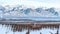 Pano House exterior with bay window against lake and mountain scenery in winter