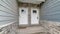 Pano Identical white wooden front doors with glass panes against stone brick wall