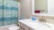 Pano Interior of bathroom with toilet beside bathtub and shower with blue curtain