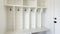 Pano Interior of a white mudroom with white garage door and wooden flooring