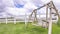 Pano Old wooden garden swing on lush green grasses inside white picket fence