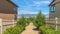 Pano Pathway with plants and picket fence amid houses with view of lake and mountain