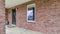 Pano Spacious and open wrap around concrete porch of house with brick exterior wall