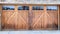 Pano Wide brown wood door with glass panes of attached garage of stone brick home