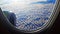 Panorama from air liner porthole to thick clouds of blue sky of airplane