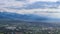 Panorama of Almaty city. The mountains of the Trans-Ili Alatau, towering above the city, are partially illuminated by the sun.