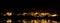 Panorama of alumina refinery at night with reflections.