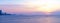Panorama of the Amur Bay at sunset with people on the icy surface of the sea