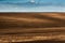 Panorama of arable land over clouds sky