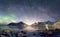 Panorama of Aurora borealis with Milky way galaxy over snow mountain in coastline