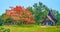 Panorama of Baan Dam Black House complex with blooming flame tree, on May 11 in Chiang Rai, Thailand