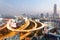 Panorama of Bangkok at dusk with skyscrapers in background and busy traffic on elevated expressways & circular interchanges