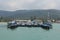 Panorama beach scape day shot of the Thailand`s Koh Samui island pier with a white sand beach, palm trees, mountains, turquoise