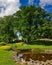 Panorama of the beautiful Kronvalda park with old oaks and small pond