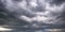 Panorama of black sky background with storm clouds. thunder front