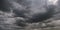 Panorama of black sky background with storm clouds. thunder front