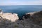 Panorama of boundless layers of blue sea water, which merges on the horizon with the sky, from the height of a rocky