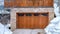 Panorama Brown wooden glass paned garage door against stone wall under balcony of home
