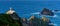 Panorama of the Cabo Ortegal lighthouse in Galicia with green cliffs and sunlight and deep blue ocean