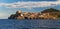 Panorama of Capraia harbour and town from the sea, rocks, yacht