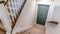 Panorama Carpeted U shaped staircase that leads down to the basement door of a home