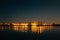 Panorama of city buildings lights reflection in water at night sky background, minimalism urban style