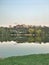 Panorama of the city park. Reflection of buildings and trees in the water. City environment.