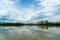 Panorama of city reflection in water under clouds during daytime