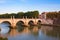Panorama cityscape from the ancient embankment Tiber in Roma at sunset. Near of bridge and castle of Angels. Saint Angelo castle
