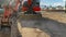 Panorama Close up of a red excavator with an attched grader blade viewed on a sunny day