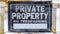 Panorama Close up view of a weathered sign that reads Private Property No Trespassing