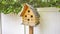 Panorama Close up of wooden birdhouse with several entrance holes at the yard of a home